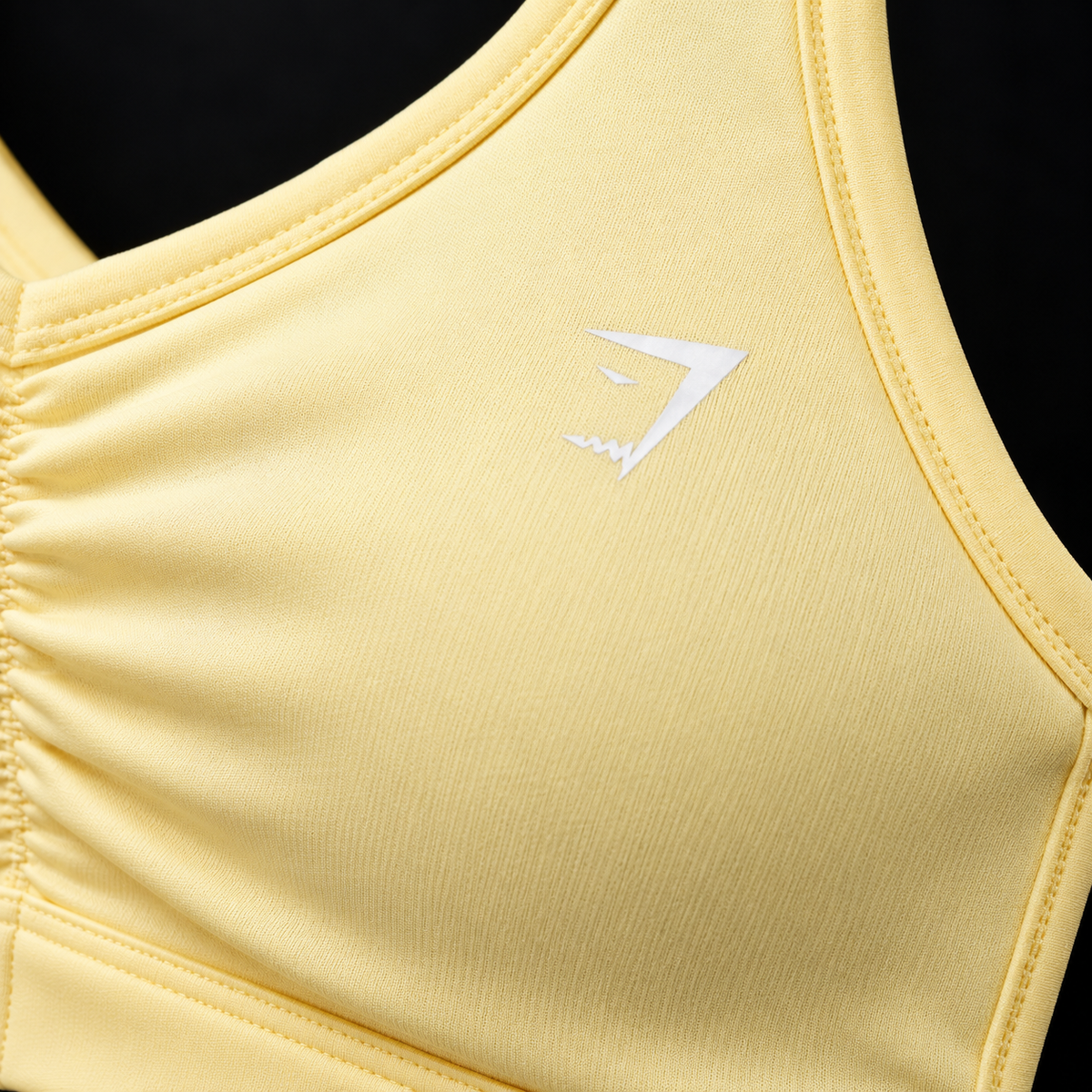 Gymshark Ruched Sports Bra Butter Yellow, detalle de logo y material — Crazy!Duck Hype