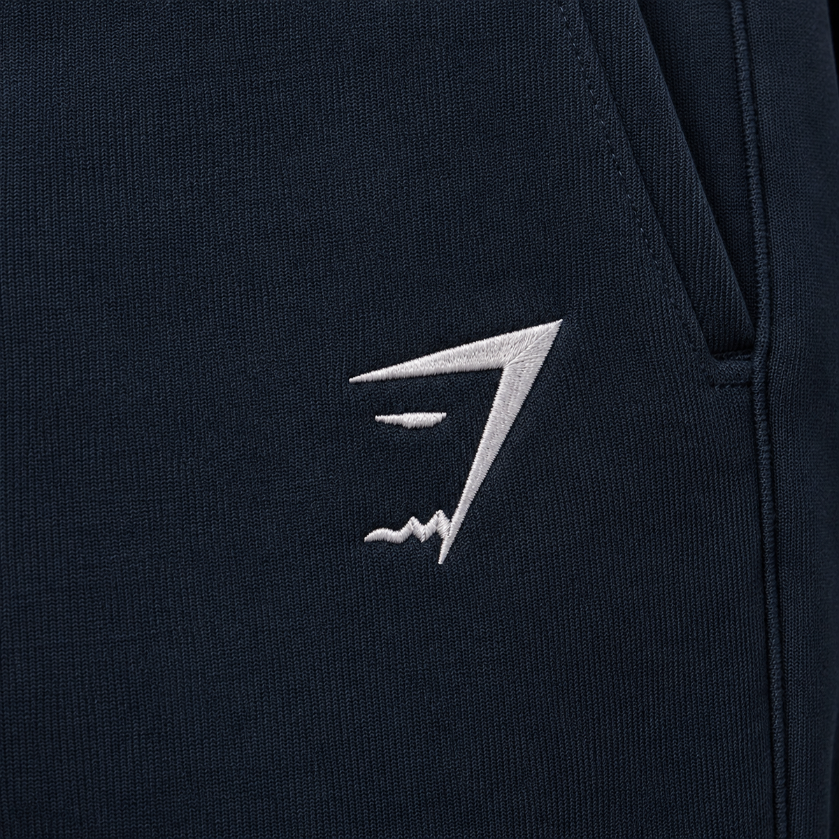 Gymshark Crest Joggers Navy, detalle de logo y bolsillo — Crazy!Duck Hype
