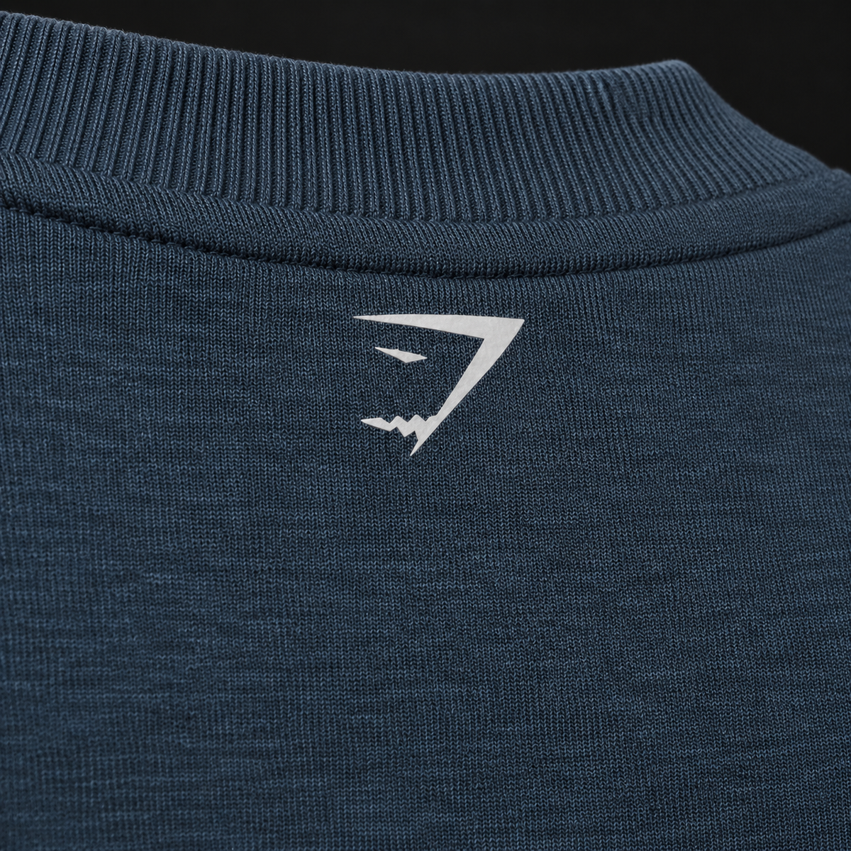 Gymshark Worn Crest Graphic Sweatshirt GS Stealth Blue, detalle de logo y material — Crazy!Duck Hype